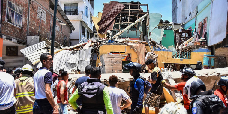 Image: Residents and rescue workers stand in front of buildings brought down by an earthquake that shook Machala, Ecuador, on March 18, 2023.