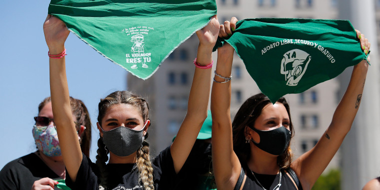 Women hold up green handkerchiefs in front of La Moneda government palace during a pro-abortion demonstration in Santiago, Chile, in 2021.