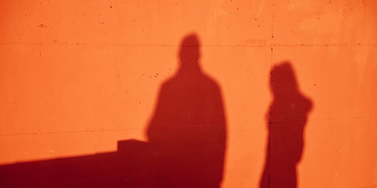 Shadows Of Man And Woman On Orange Wall