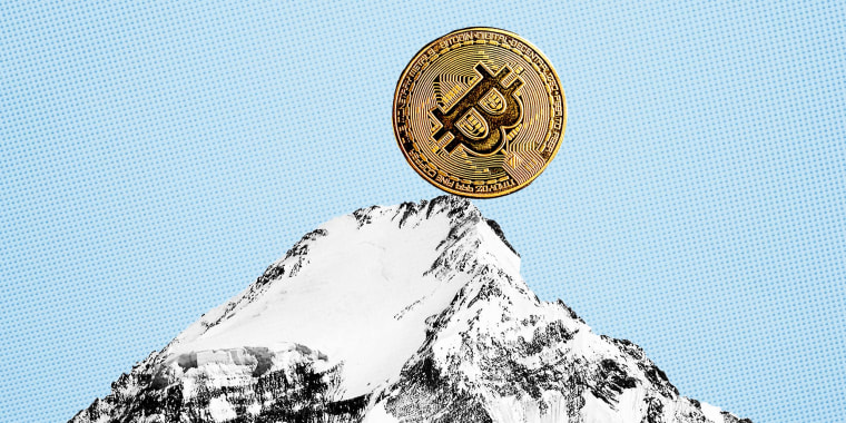Photo Illustration: A bitcoin perched at the top of a mountain peak, on the verge of rolling down