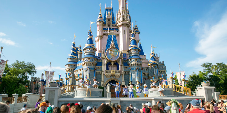 People watch mascots perform onstage in front of Cinderella's castle at Walt Disney World Resort.
