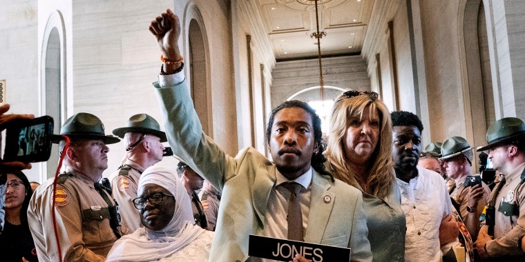 Metro Nashville Council member Zulfat Suara, left, and State Rep. Gloria Johnson escort State Rep. Justin Jones back to the House chamber on April 10, 2023, in Nashville.