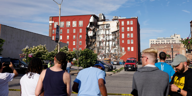 Onlookers watch as emergency crews work the scene of a partial building collapse Sunday on Main Street in Davenport, Iowa. 