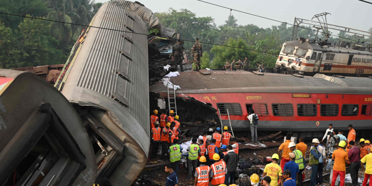 Rescue workers gather around damaged carriages at the accident site of a collision near Balasore in the eastern state of Odisha, on June 3, 2023.  