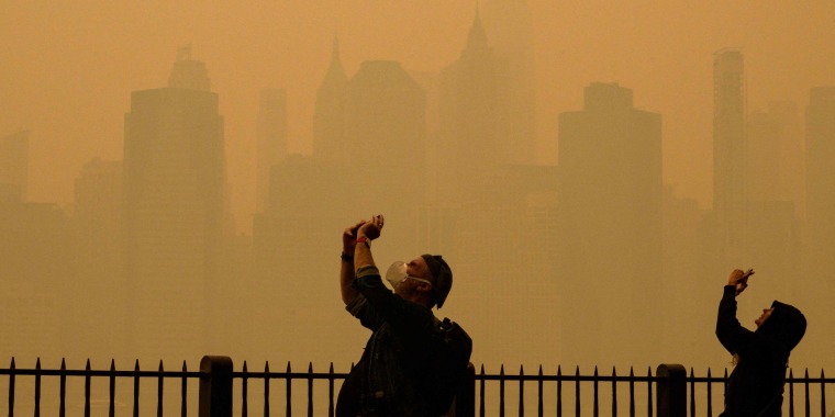 People take photos of the sun as smoke from the wildfires in Canada cause hazy conditions in New York City on June 7, 2023. 
