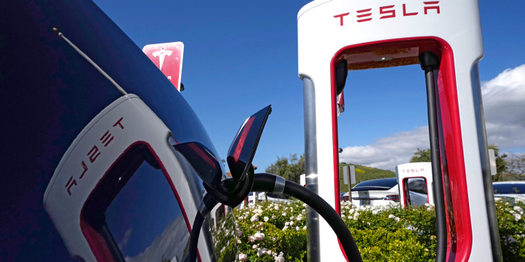 A Tesla auto charges at a charging station