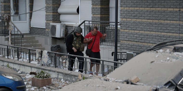 Un policía ayuda a un hombre herido a dirigirse a una ambulancia luego de salir de un edificio residencial de varios pisos que resultó dañado por una incesante oleada de bombardeos, el martes 30 de mayo de 2023, en Kiev, Ucrania.