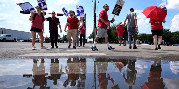 UAW union members picket on the street in front of a Stellantis distribution center on Sept. 25, 2023, in Carrollton, Texas. 