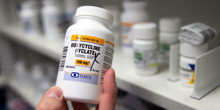 A pharmacist holds a bottle of the antibiotic doxycycline hyclate