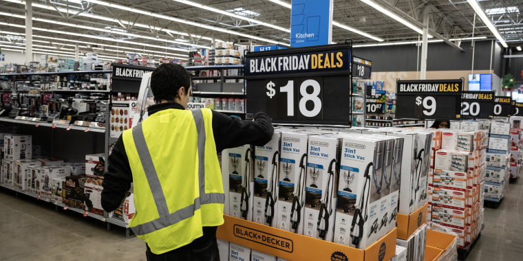 A worker stocks vacuums at a Walmart store on Black Friday in Secaucus, N.J., on Nov. 24, 2023.