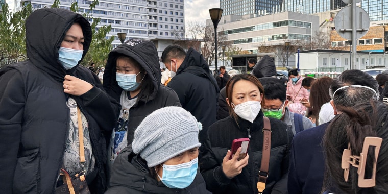 People wait for their rides outside a children's hospital in Beijing