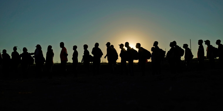 Migrants who crossed the Rio Grande and entered the U.S. from Mexico are lined up for processing by U.S. Customs and Border Protection on Sept. 23, 2023, in Eagle Pass, Texas. 
