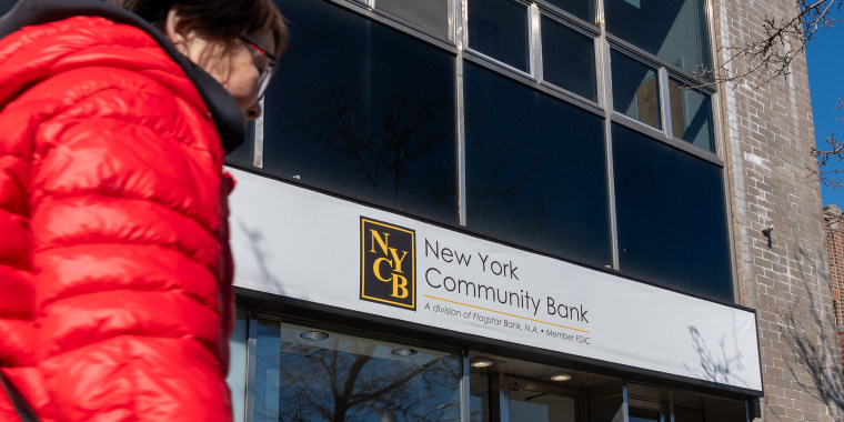 A person passes by a New York Community Bank branch in Brooklyn.