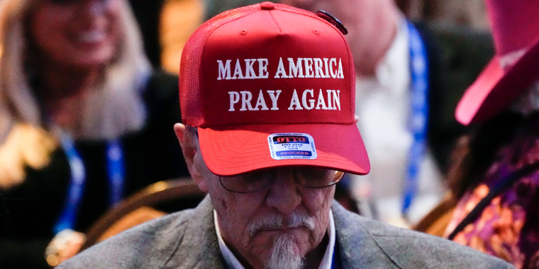 A man wears a 'Make America Pray Again' hat