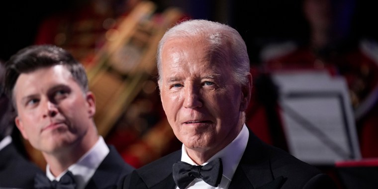 President Joe Biden sits as host Colin Jost, left, looks on at the White House Correspondents' Association Dinner in Washington on Saturday, April 27, 2024.