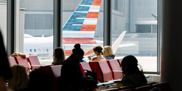 Passengers wait to board a flight 