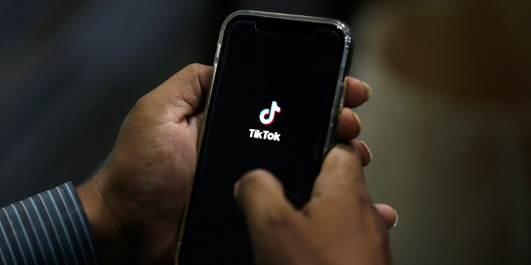 Close up hands holding a phone with the Tik Tok mobile app