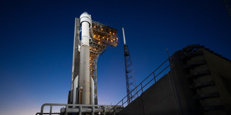 United Launch Alliance Atlas V rocket with Boeing's CST-100 Starliner spacecraft aboard illuminated by spotlights on the launch pad 