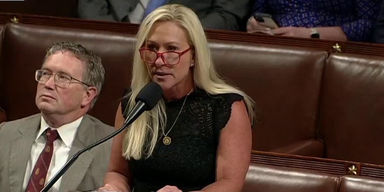 Marjorie Taylor Greene speaking at the microphone on the House floor