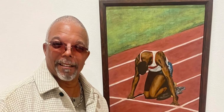 Alonzo Adams posing in front of his first oil panting, The Start.
