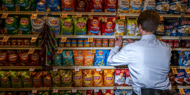A worker arranges chips at a grocery store