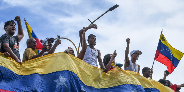Protesters demonstrate holding the flag of Venezuela