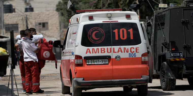 A Palestinian paramedic shows his bullet proof vest to the members of the Israeli forces inside an armoured vehicle during a military operation in the West Bank city of Jenin, Wednesday, Aug. 28, 2024. (AP Photo/Majdi Mohammed)