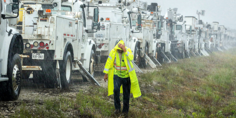 A lineman with Team Fishel, is pelted with rain.