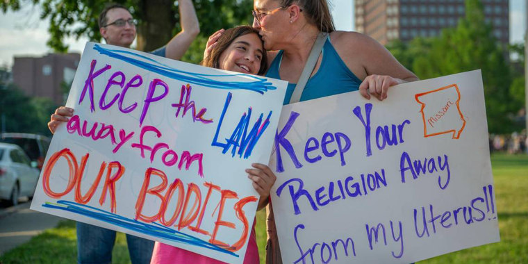 Eleven-year-old Giuliana Cangelosi, left, and her mother Nichole Cangelosi share a moment together while attending a protest opposing the Supreme Court's ruling overturning federal protections for abortion rights June 24, 2022, in Mill Creek Park at Country Club Plaza in Kansas City, Missouri. 