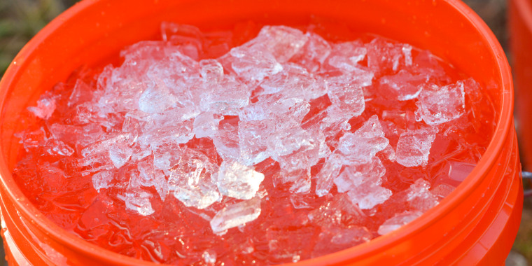 A detail photo of a bucket with ice water in it.