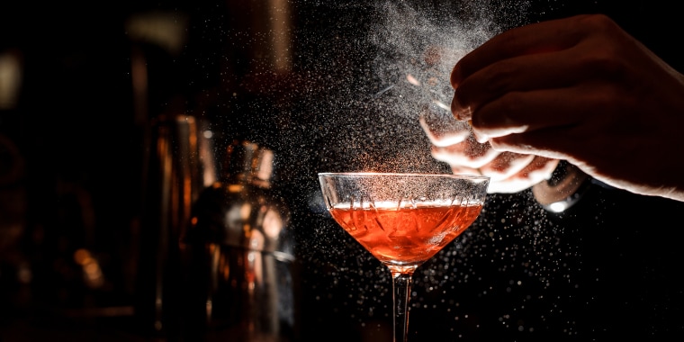 A bartender prepares a drink. 