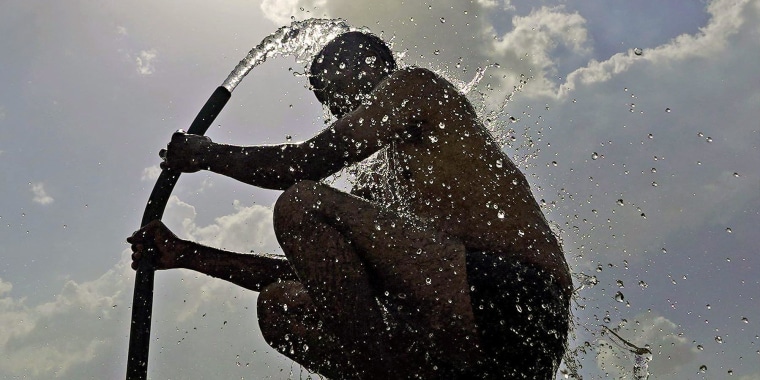 A man cools off with a hose during a heatwave in Ajmer, India, in June 2024.