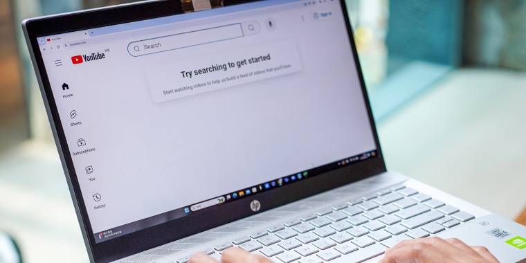 A woman browses Youtube website on her laptop.