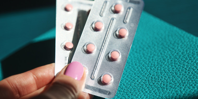 Woman's hands holding HRT pills
