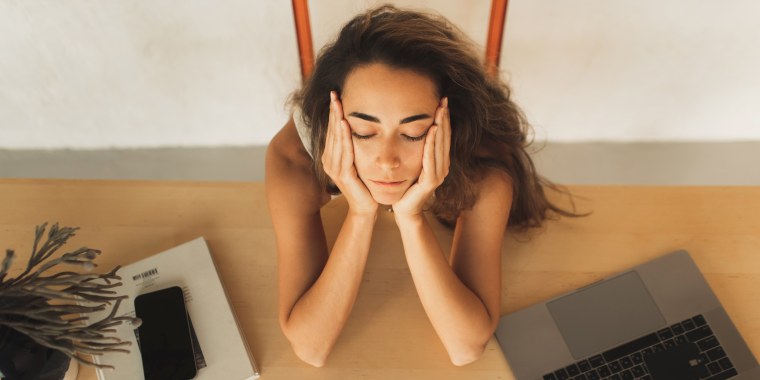 Tired and upset woman sleeping on workplace table in office. Entrepreneur startup business, deadline