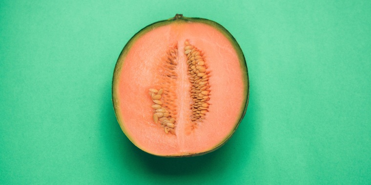 cantaloupe melon cut in half on green background