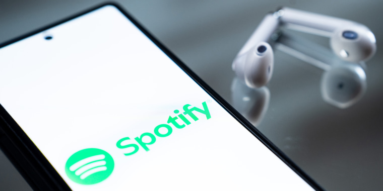 The Spotify logo appears on a smartphone screen.