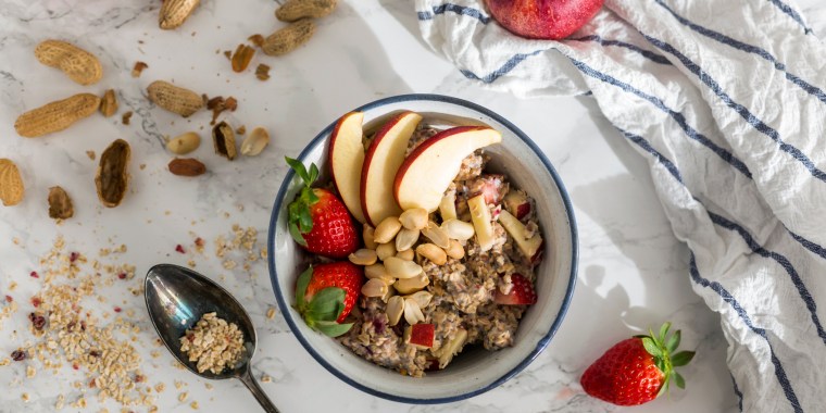 Bowl of oats porridge topped with fruit and nuts