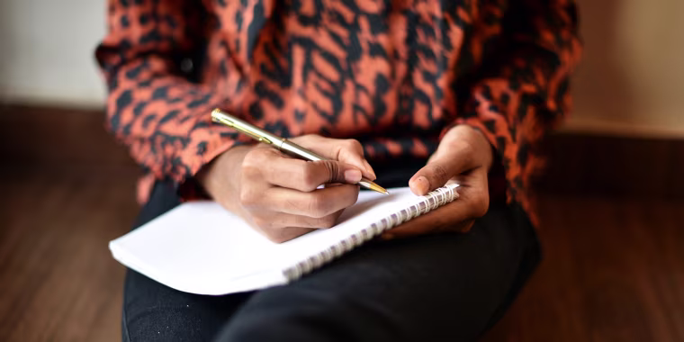 Image: Woman writing on Notepad