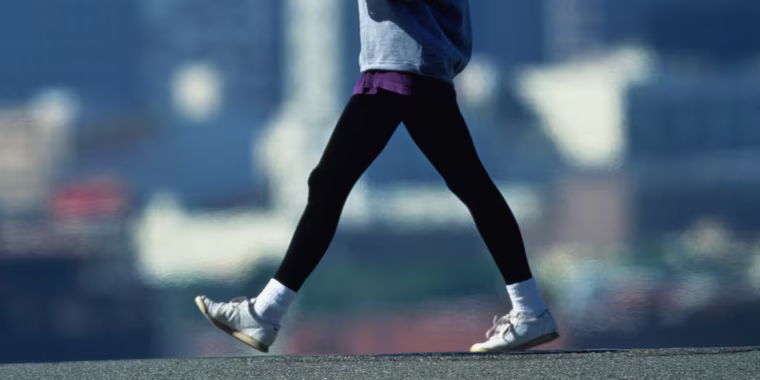 Woman speed walking in fore of city skyline
