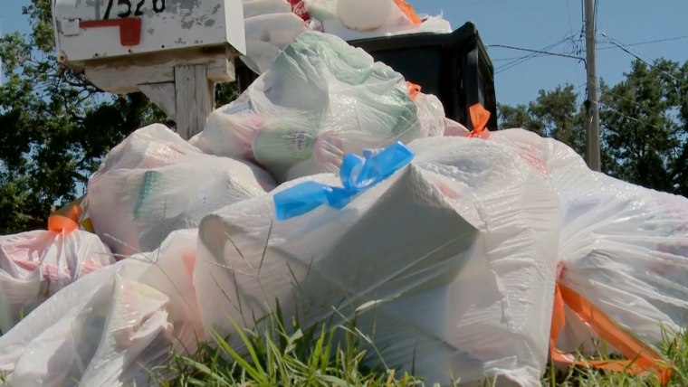 Heap of plastic trash bags on curb waiting for sanitation pickup
