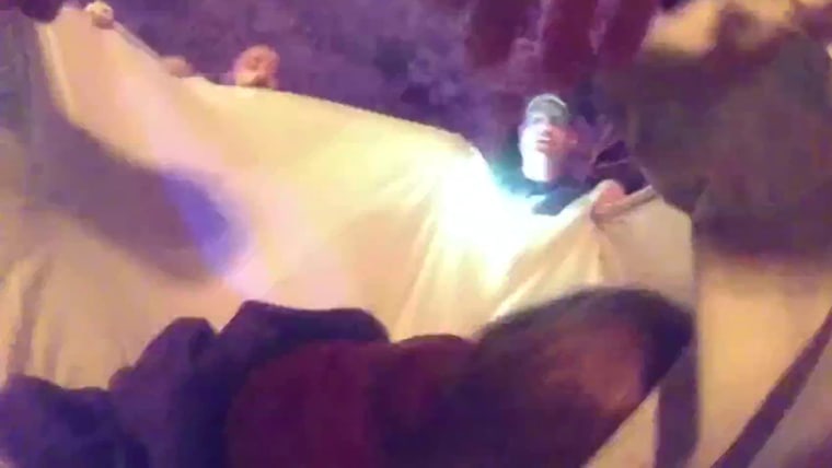 Rescuers use a blanket to catch girl jumping from burning building
