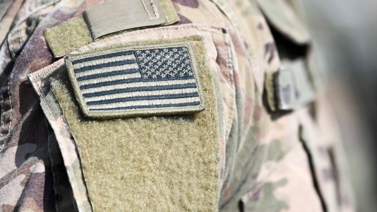 A soldier of the US army wears the country's flag on his uniform during the 'Dynamic Front 22', the US Army led NATO and Partner integrated annual artillery exercise in Europe, in Grafenwoehr, near Eschenbach, southern Germany, on July 20, 2022. - The 'Dynamic Front 22' exercise, led by 56th Artillery Command, is the premier US led NATO and Partner integrated artillery exercise in Europe and includes more than 3000 participants from 19 nations. Allied artillery and supporting units practice integrating joint fires and test interoperability in a multi-national enviroment until 24 July, 2022.
