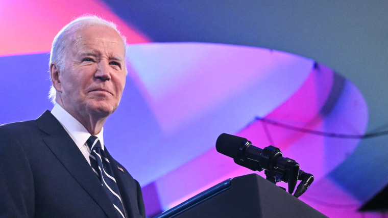 President Joe Biden stand at the podium