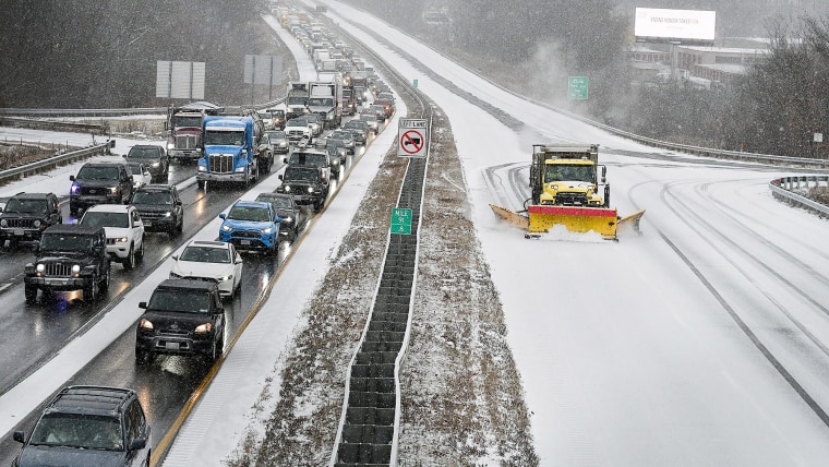 The photo shows vehicles stopped on the westbound side and a plow, headed west, on the eastbound side.