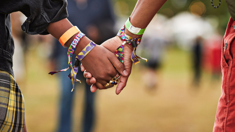 Young couple with wristbands holding hands