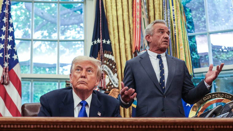 Donald Trump sits at his desk, left, in the oval office while Robert F Kennedy Jr stand behind him and speaks while gesturing