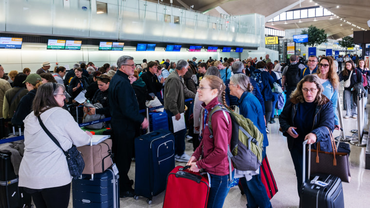 People wait in line for a delayed flight at Newark International Airport