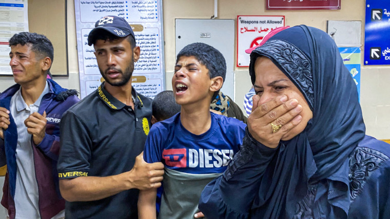 Palestinians react as they await news of a relative who was injured in Israeli strikes.