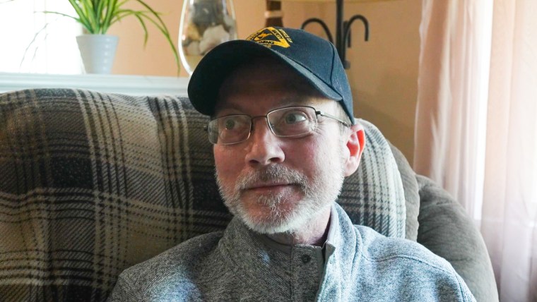 Eric Tennant seated on a couch